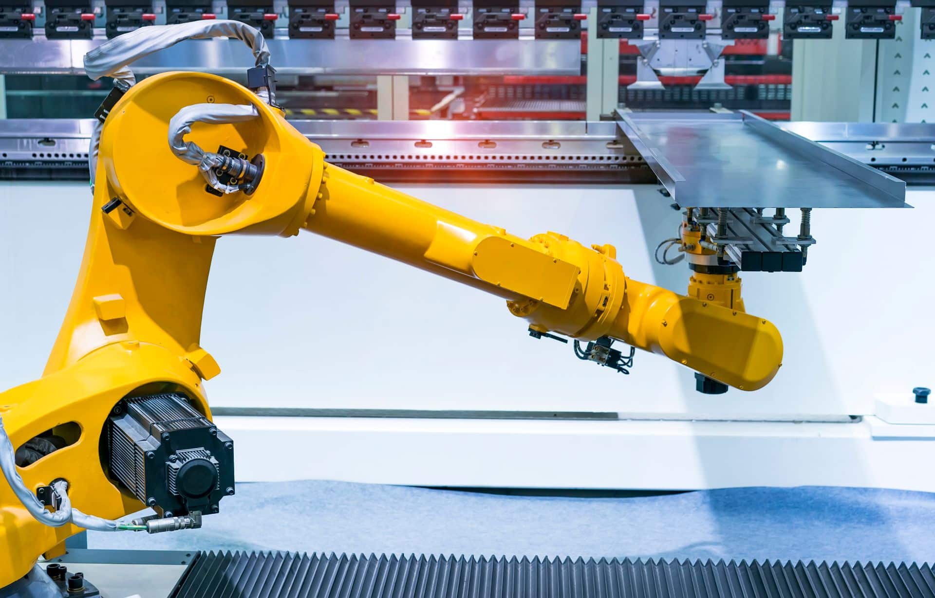 Gelber Roboterarm in industrieller Fertigung bei automatisierter Materialbearbeitung mit Vakuumtechnik
